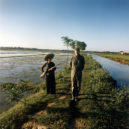 Američtí zajatci ve Vietnamu - The captured US pilot major Pewey Waddell is being guarded by a militiawoman with a gun and a bayonet on a rice field – 1967