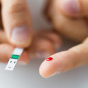 Světový den diabetu připadá na 14. listopad - close up of male finger with blood and test stripe